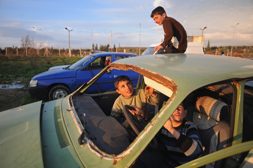 Syrian children play in a junkyard of old, abandoned and destroyed vehicles at the entrance to the Reyhanli tent city on February 26, 2012.  As the year old rebellion against the rule of Bashar Al-Assad continues just across the border in Syria, Turkey has seen a continued influx of refugees from the Syrian conflict but has not granted them refugee status and instead considers them to be "guests" of Turkey, the sign of another conflict fissure located precariously close to the pipeline route.